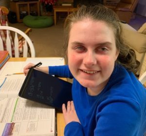 Young lady with aniridia works on computer tablet